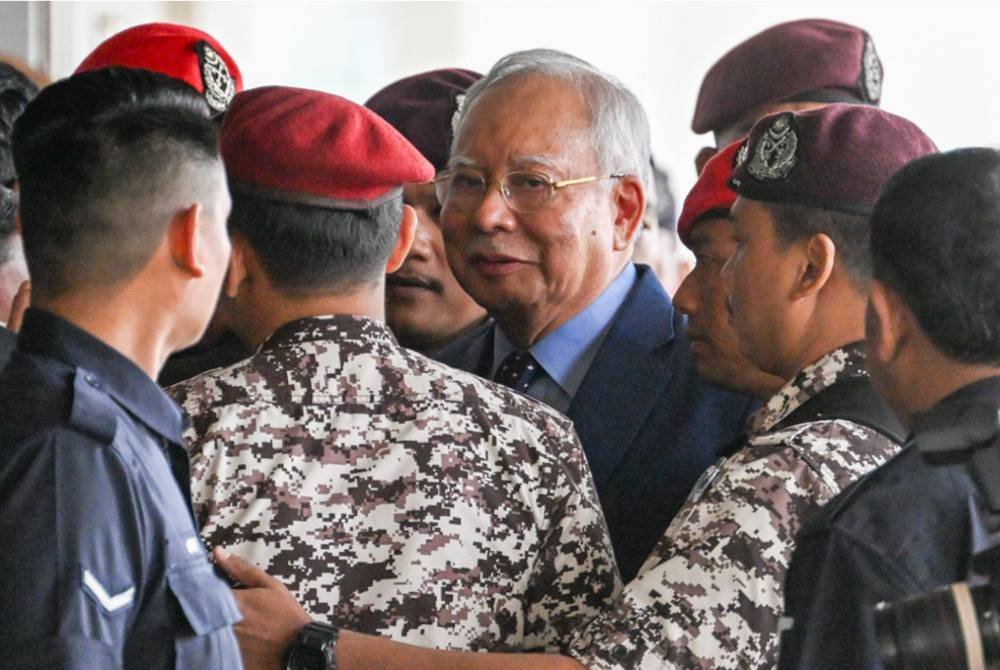 Najib (tengah) hadir di Kompleks Mahkamah Kuala Lumpur pada Rabu. Foto AFP