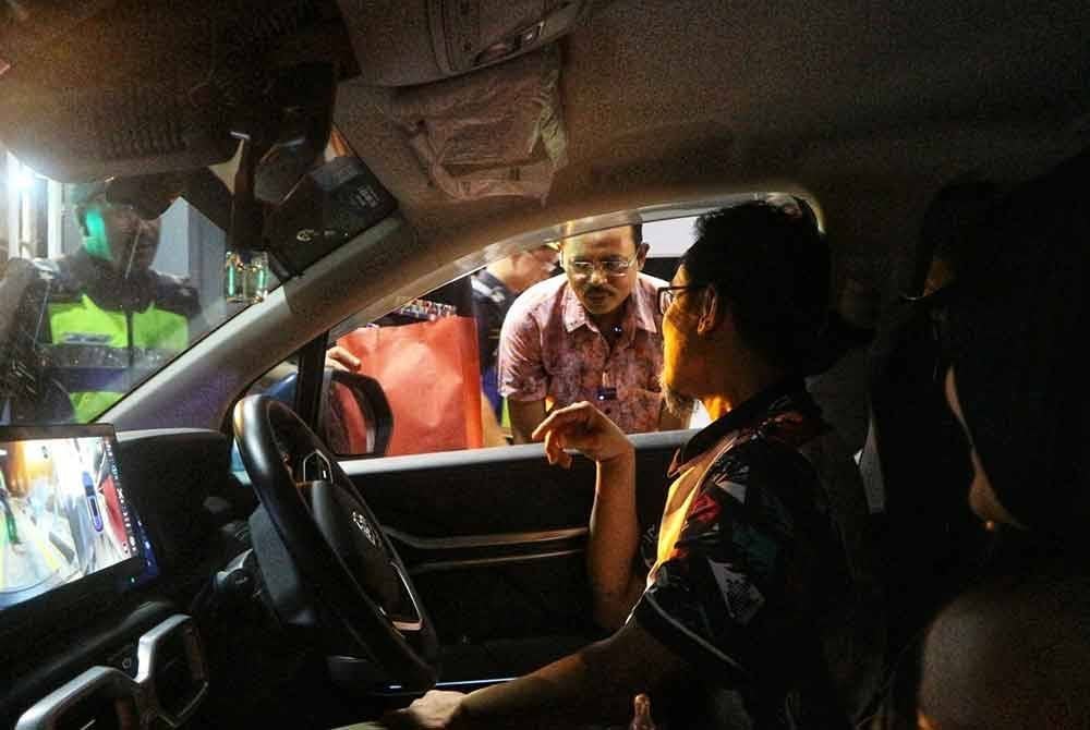 Razali ketika bertanyakan sesuatu kepada pengguna di plaza Tol berkenaan.
Foto ihsan JPJ Pahang