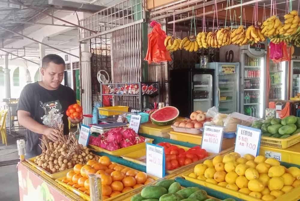 Mohammad Fakrul Akmal meneruskan perniagaan jualan buah-buahan di simpang empat Bandar Seri Jempol.