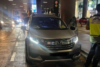 Anggota JPJ melakukan pemeriksaan ke atas seorang 'ulat' yang cuba memujuk dua pelancong warga China menggunakan perkhidmatan kereta sewa secara haram di Terminal 2, KLIA pada Selasa.
Foto: JPJ.