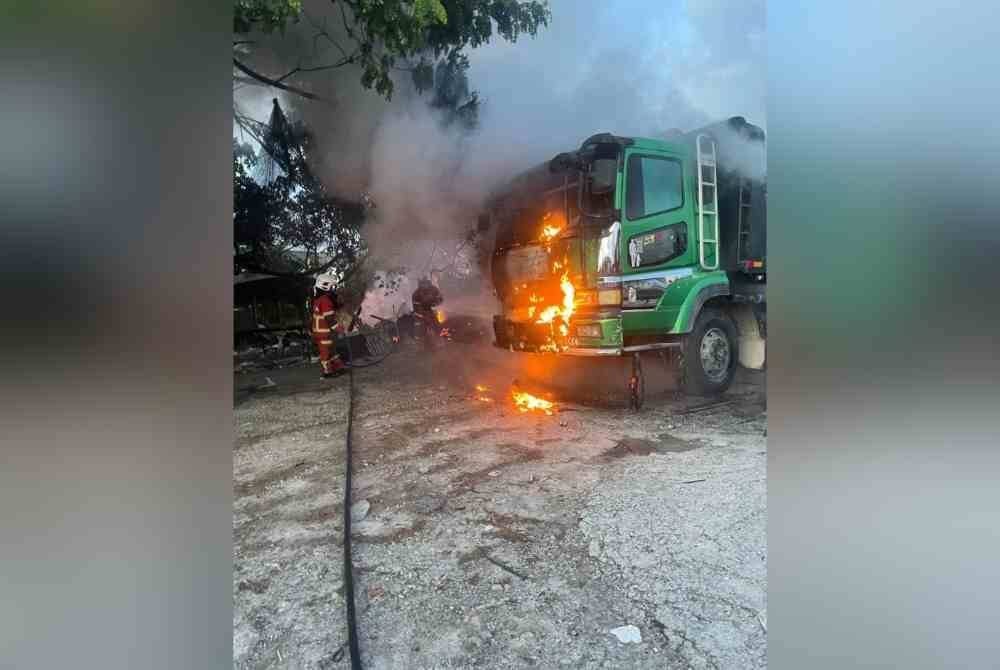 Anggota bomba ketika memadam api pada sebuah lori yang turut terbakar dalam kejadian tersebut.