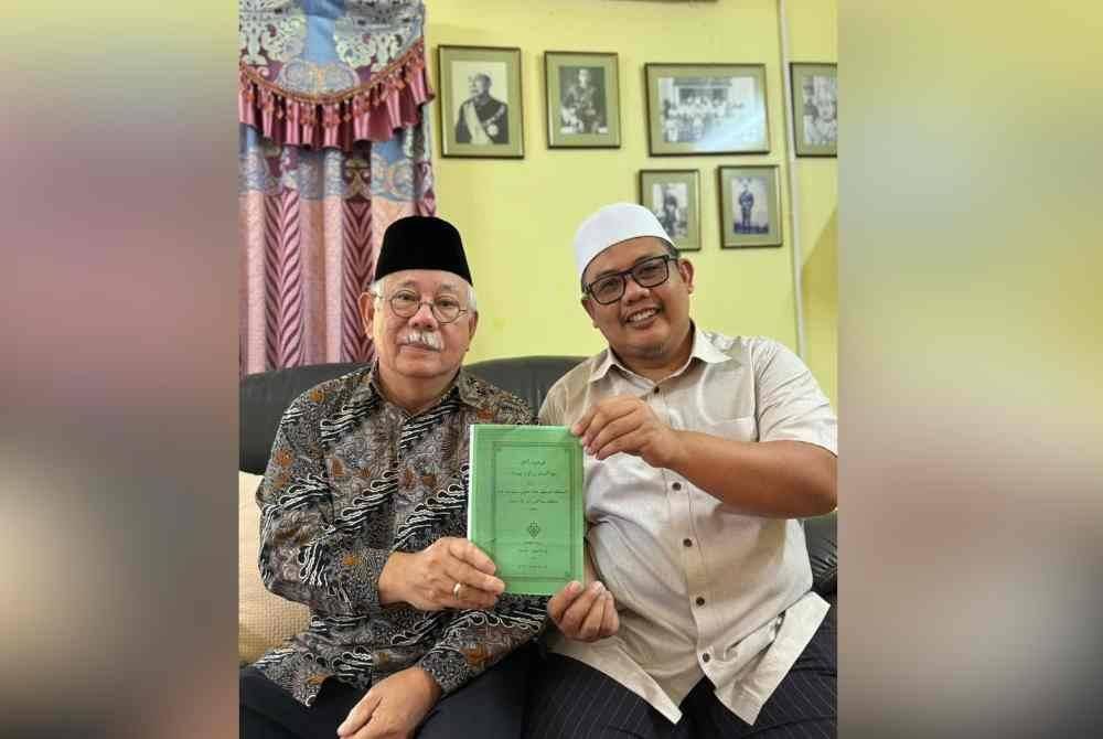 Jamaluddin (kiri) menunjukkan kitab Pohon Agama yang boleh dijadikan panduan ilmu asas tauhid.