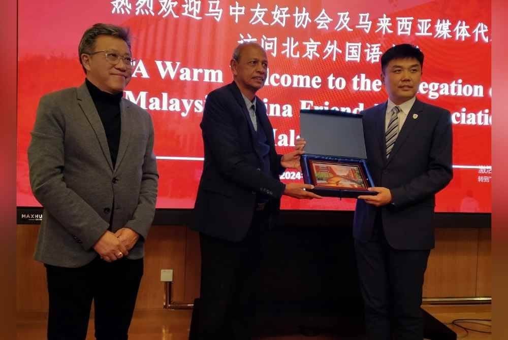 Abdul Majid (tengah) menerima cenderahati daripada Naib Presiden Beijing Foreign Studies University, Prof Zhao Gang dalam lawatan ke universiti berkenaan.