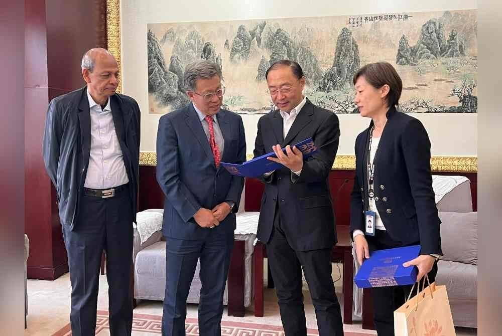 Abdul Majid (kiri) bersama Chun Wai (dua dari kiri) melihat cenderahati yang disampaikan kepada wakil CMG dalam lawatan ke konglomerat media China tersebut di Beijing.