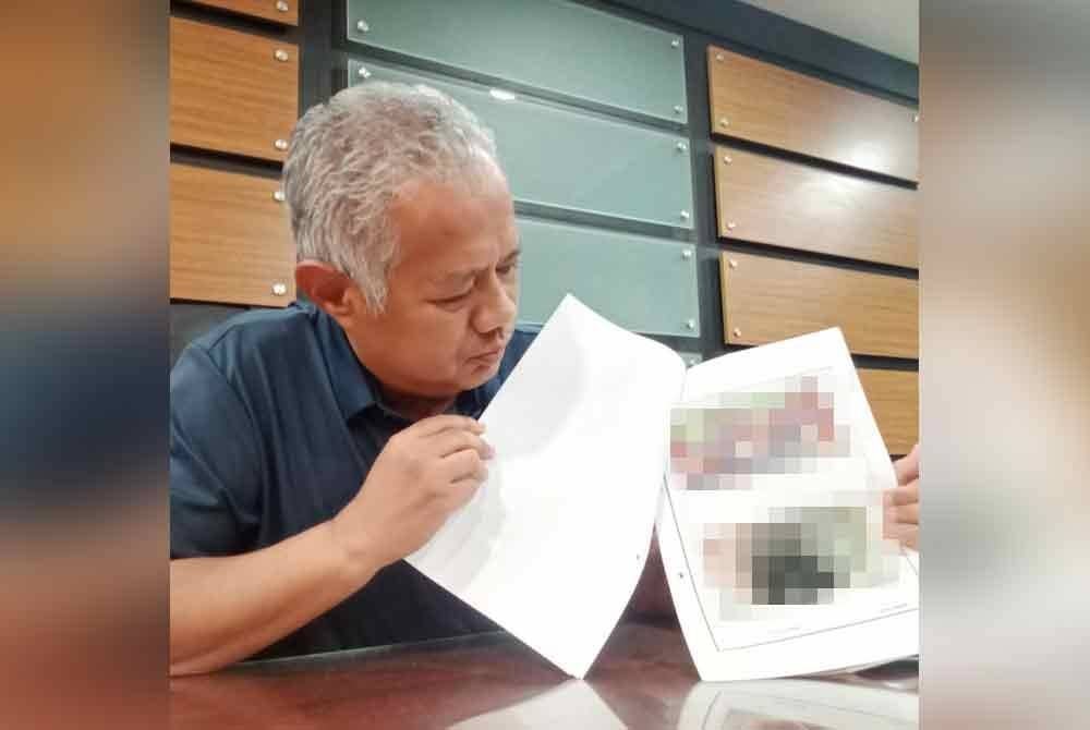 Mohd Zamri menunjukkan gambar perigi hasil siasatan di lokasi.
