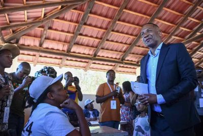 Duma Boko (kanan) selepas menerima kertas undi daripada pegawai pilihan raya di Gaborone pada 30 Oktober, semasa pilihan raya umum Botswana. Foto AFP