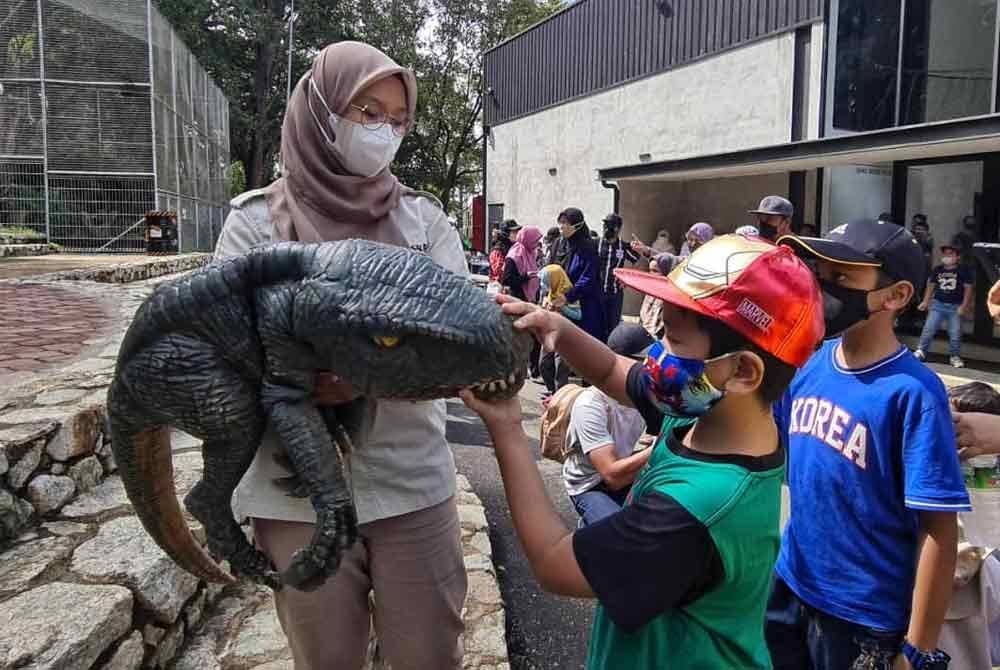 Pengunjung kanak-kanak teruja apabila diberi peluang untuk menyentuh dinosaur.