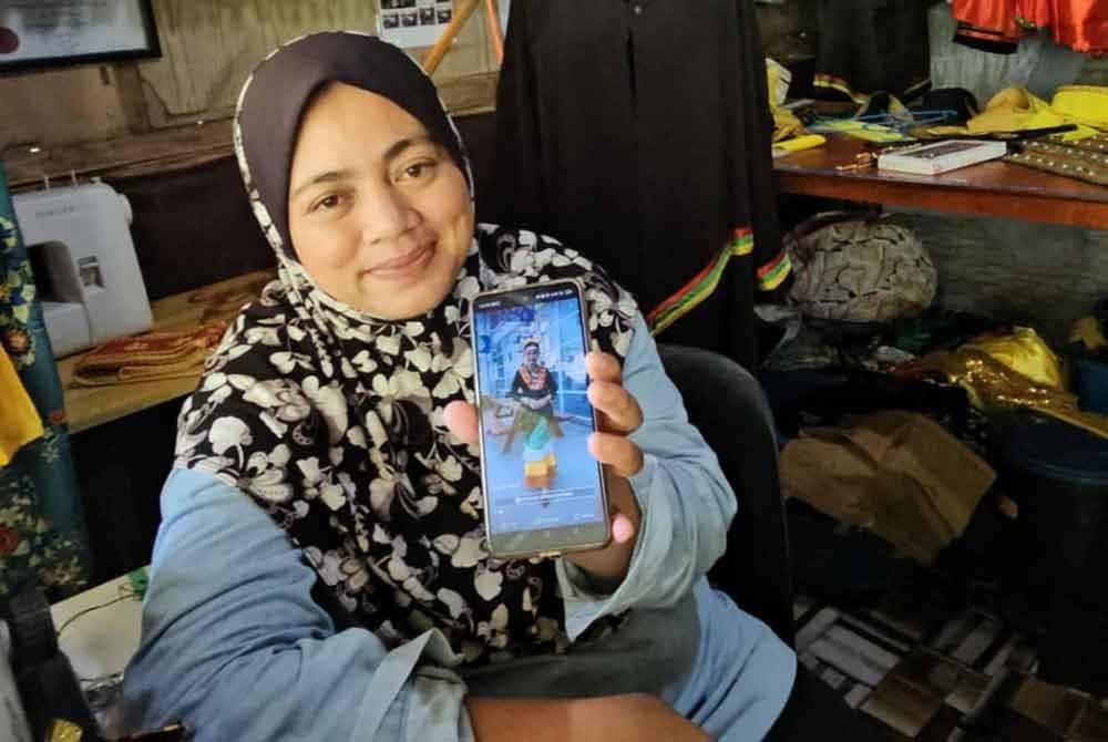 Roslinah menunjukkan gambar Qahirah Maisarah ketika menyarungkan baju etnik Bisaya yang direkanya khas untuk dipakai di California.