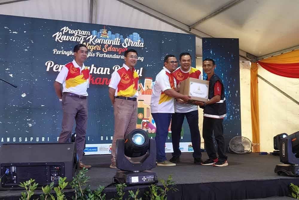 Amirudin (tengah) menyampaikan sumbangan kotak makanan kepada penerima pada Program Rewang Komuniti Strata Negeri Selangor di Pangsapuri Baiduri Bandar Tasik Kesuma pada Sabtu.