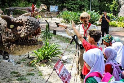 Renjer memberi penerangan kepada pengunjung mengenai haiwan animatronik prasejarah. Foto FB Zoo Teruntum