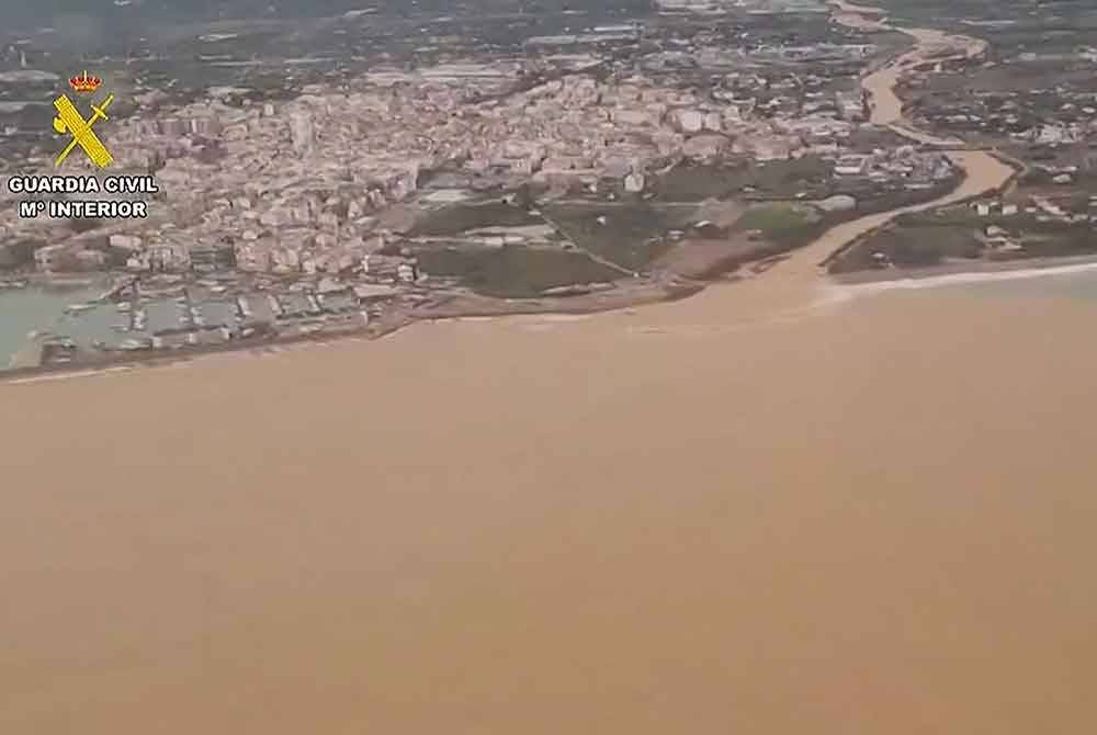 Air berlumpur mengalir turun dari sungai ke laut berhampiran Benicarlo, di wilayah Valencia. Foto AFP
