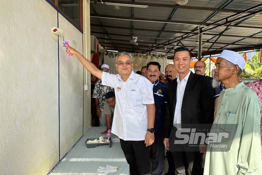 Makhzan (kanan) mengecat dinding Masjid Jamek Mukim Bukit Tanah, Selising, Pasir Puteh. Foto Sinar Harian/ADILA SHARINNI WAHID.
