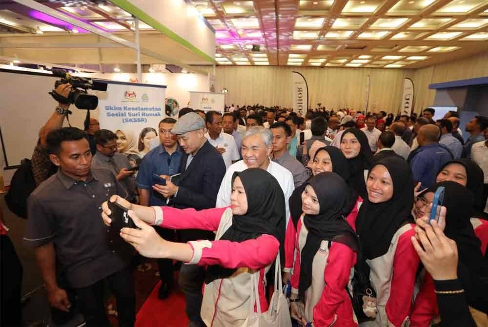 Ahmad Zahid bergambar bersama pelajar yang hadir pada Majlis Pembangunan Bakat Johor dan Karnival Kerjaya di Pusat Konvensyen Antarabangsa Persada, Johor Bharu pada Ahad