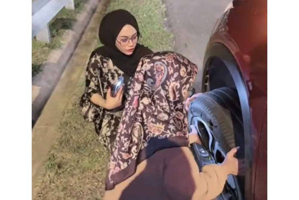 Anis Syazwani dan rakan-rakan menggunakan YouTube sebagai panduan menukar tayar rosak.