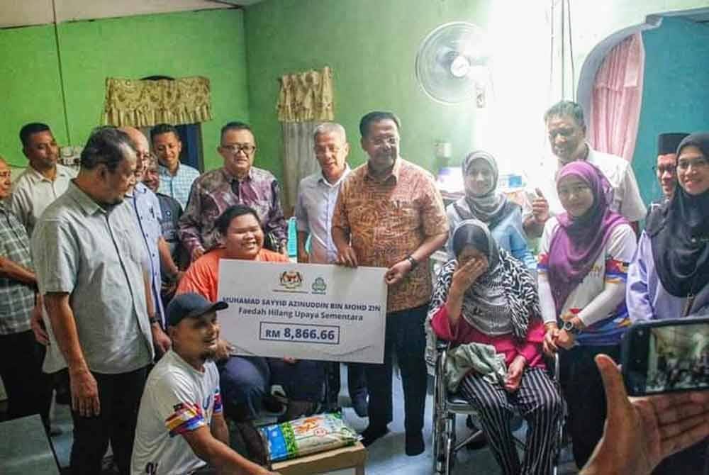 Bantuan PERKESO disampaikan oleh Timbalan Menteri Sumber Manusia, Datuk Seri Abdul Rahman Mohammad (enam dari kanan) kepada Muhammad Sayyid (tiga dari kiri) baru-baru ini.