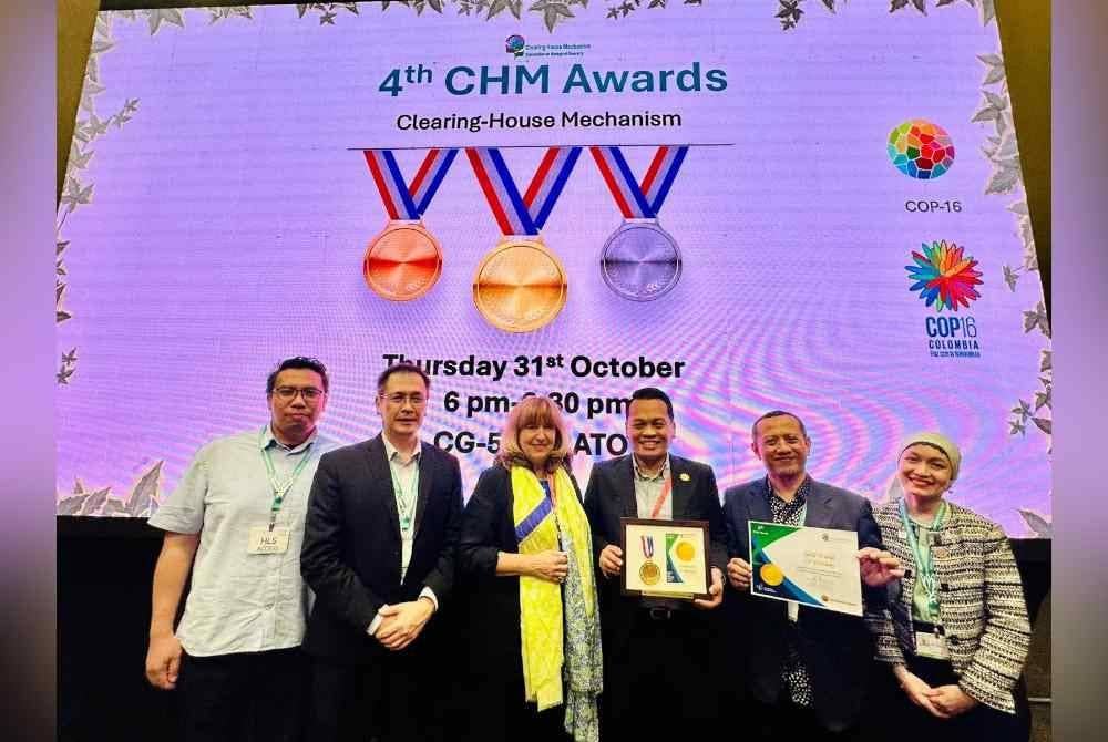 Nik Nazmi (tiga dari kanan) menerima anugerah berkenaan daripada Setiausaha Eksekutif CBD, Astrid Schomaker. Foto NRES