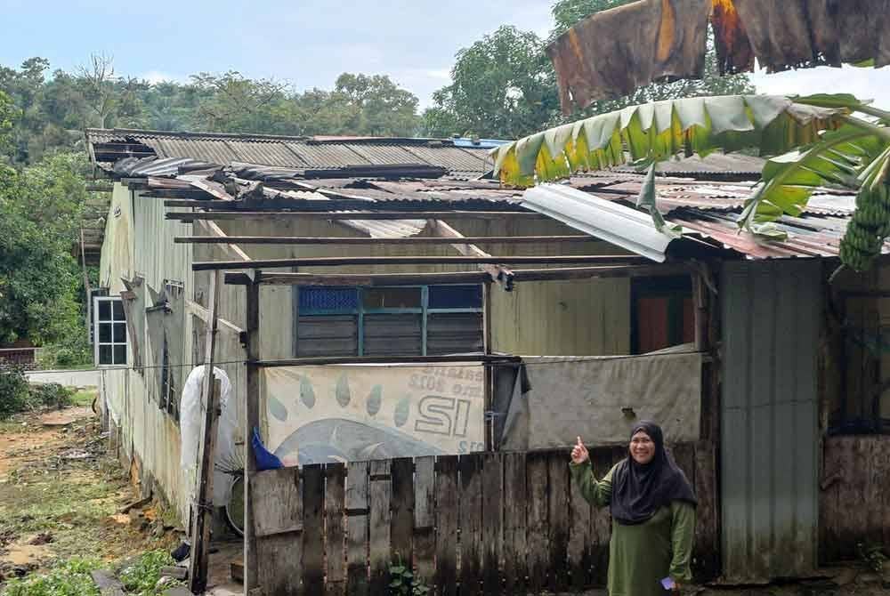 Isteri kepada Muhammad Yusop menunjukkan keadaan rumahnya yang rosak di Felda Panching Utara di Kuantan pada Isnin.