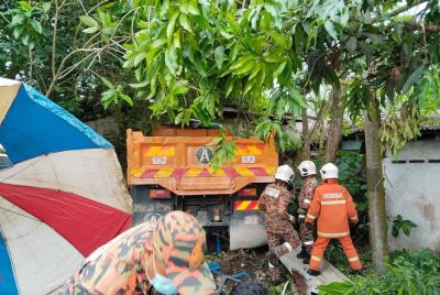 Tiga lelaki cedera selepas sebuah lori tanah terbabas dan merempuh warung di tepi jalan di Batu 8, Jalan Gambang di sini, petang Isnin. Foto JBPM Pahang.