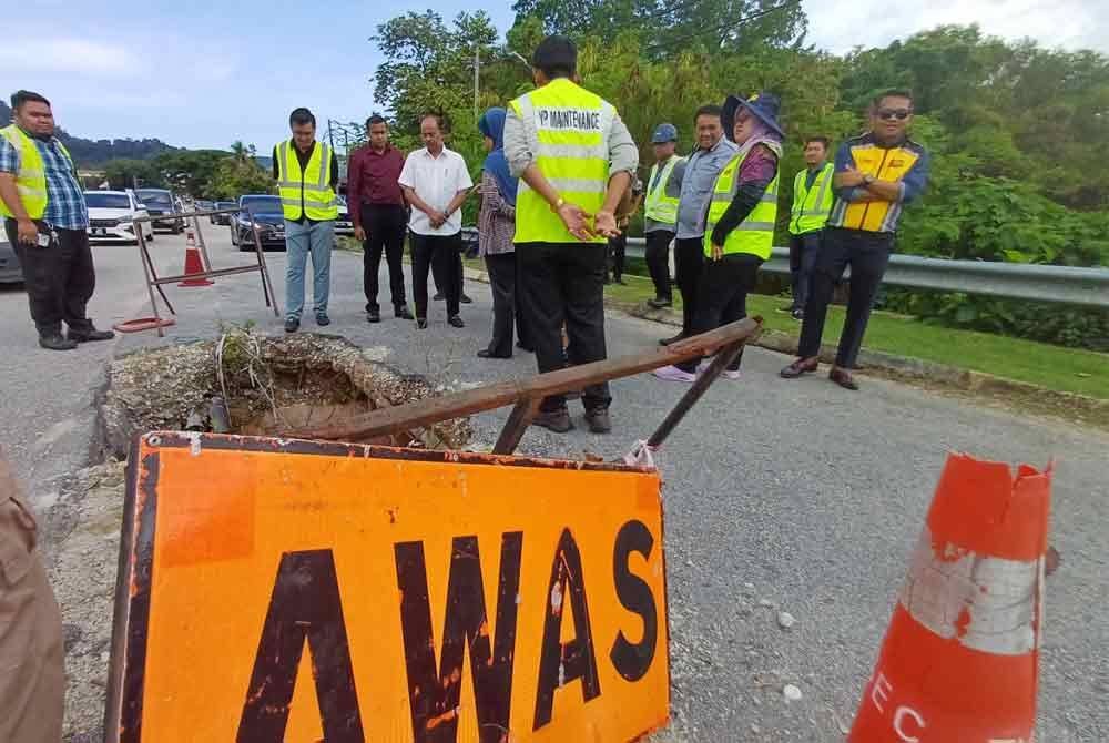 Ir Razali (empat dari kiri) meninjau keadaan jalan yang berlubang besar itu selepas ia tular pada Selasa