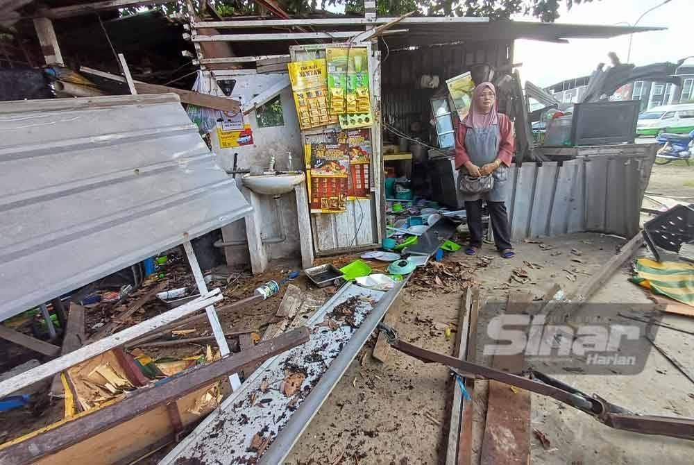 Maimum melihat keadaan warungnya yang musnah selepas dirempuh lori dalam kejadian pada petang Isnin.