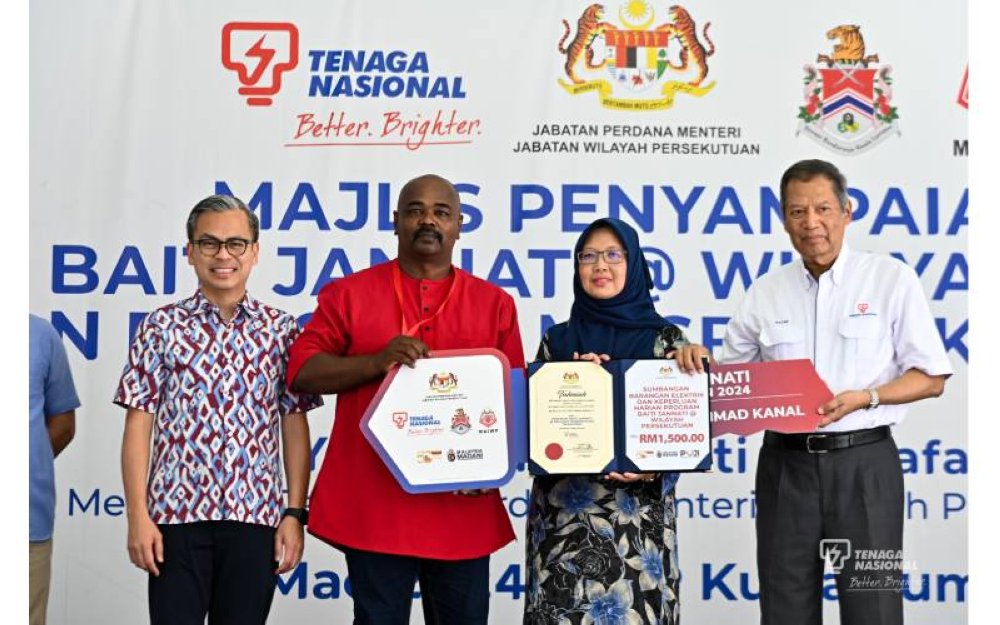 Menteri Wilayah Persekutuan, Dr. Zaliha Mustafa (dua dari kanan) menyerahkan sumbangan kepada penerima Program Baiti Jannati @ Wilayah Persekutuan, Mohamad Rizal Ahmad Kanal (tiga dari kanan) dan disaksikan oleh Menteri Komunikasi, Fahmi Fadzil dan Abdul Razak. 