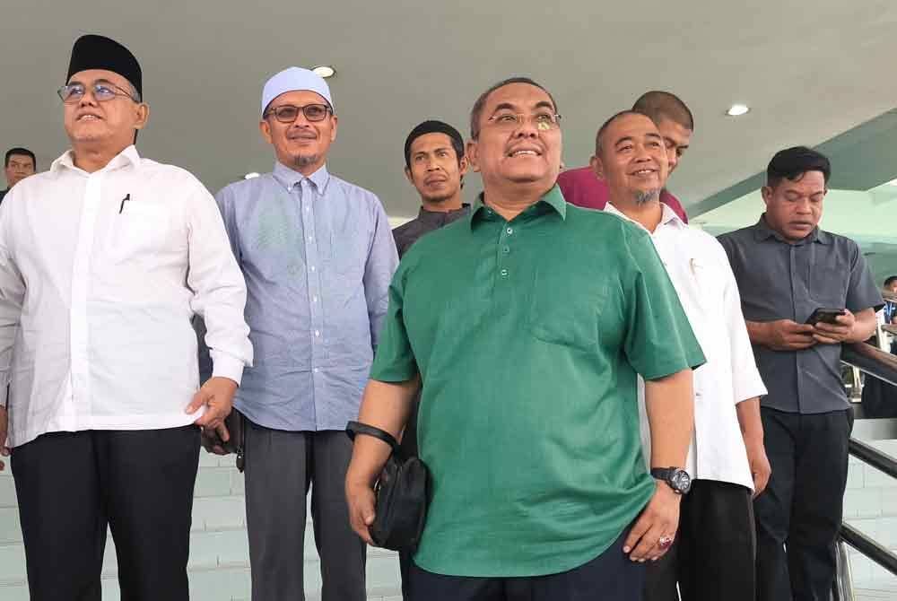 Sanusi (tiga dari kanan) berkemeja hijau, hadir ke Mahkamah Tinggi Shah Alam pada Rabu, bagi sebutan dua kes menghasut berhubung pelantikan Menteri Besar Selangor dan penubuhan Kerajaan Perpaduan dalam satu ceramah politik tahun lalu.