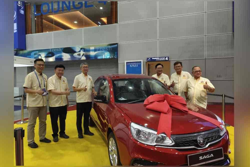 Hock San (tiga dari kiri) menunjukkan Proton Saga menanti pemenang cabutan bertuah pada Konvensyen Dunia Fujian ke-11.
