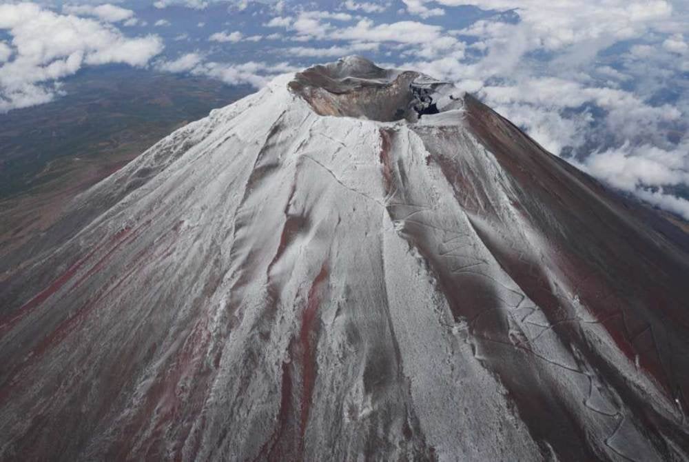 Gunung Fuji diselimuti salji pertama musim ini pada Rabu menjadikannya tarikh paling lewat dalam rekod berikutan cuaca panas yang luar biasa. Foto Kyodo