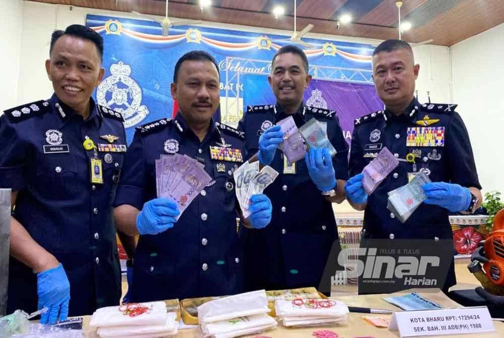 Mohd Yusoff (dua dari kiri) menunjukkan wang tunai yang dirampas dipercayai hasil jualan dadah.