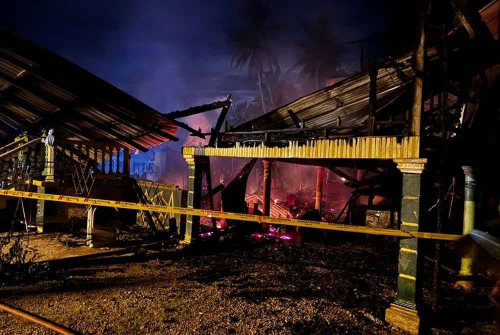 Seorang ibu pengsan selepas melihat rumahnya di Kampung Merbau, Alor Pasir, Pasir Mas terbakar pada malam Selasa. Foto JBPM