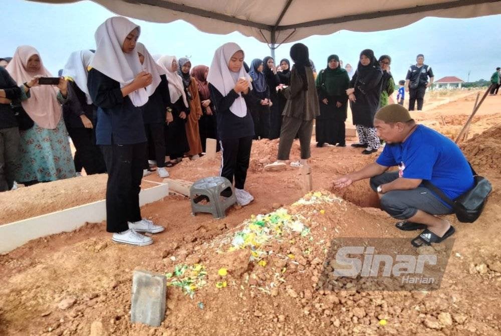 Rakan dan saudara Allahyarham Adam Benjamin memberi penghormatan akhir di Tanah Perkuburan Islam Cahaya Masai, Pasir Gudang, pada Rabu.
