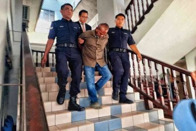 Govindaraju (tengah) ketika dibawa keluar dari Mahkamah Majistret Melaka pada Rabu.