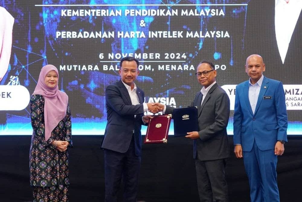 Ruji (dua kiri) menyerahkan dokumen MoU kepada Kamal (dua kanan) sambil disaksikan Fadhlina dan Armizan pada Majlis Menandatangtani MoU antara KPM dan MyIPO di Menara MyIPO, Petaling Jaya pada Rabu.