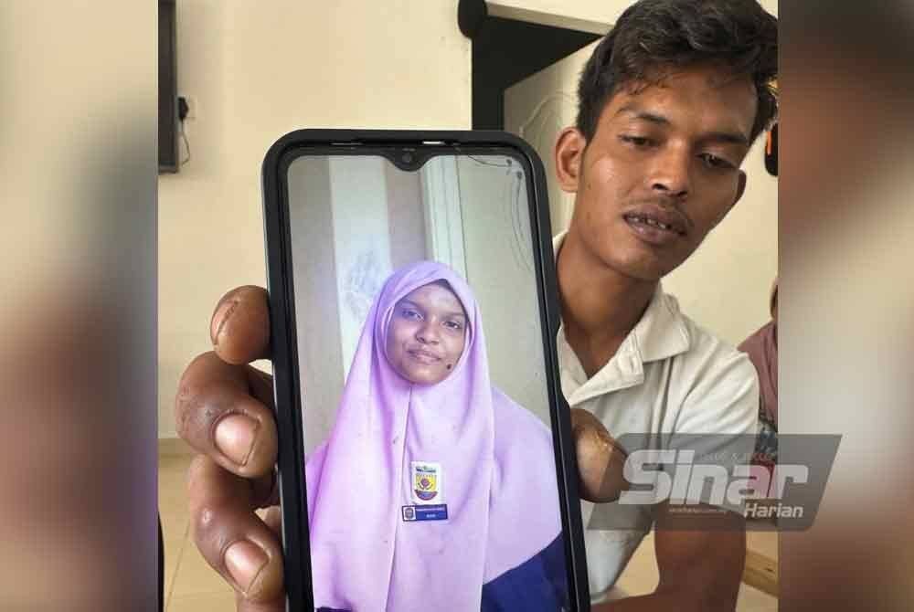 Ahmad Azizi menunjukkan gambar Ainun Mardiah ketika pemberita ditemui di rumahnya di Kota Bharu. - FOTO SINAR HARIAN-ADILA SHARINNI WAHID.