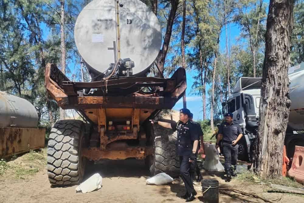Saharuddin menunjukkan dua buah 'skid tank' yang digunakan sebagai tempat simpanan minyak dalam serbuan di sebuah tapak projek pemuliharaan muara sungai di Setiu.