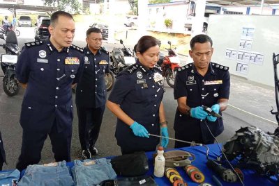 Sasikala (dua dari kanan) menunjukkan antara komponen motosikal yang dirampas susulan tangkapan 10 lelaki. dipercayai terlibat melakukan samun.