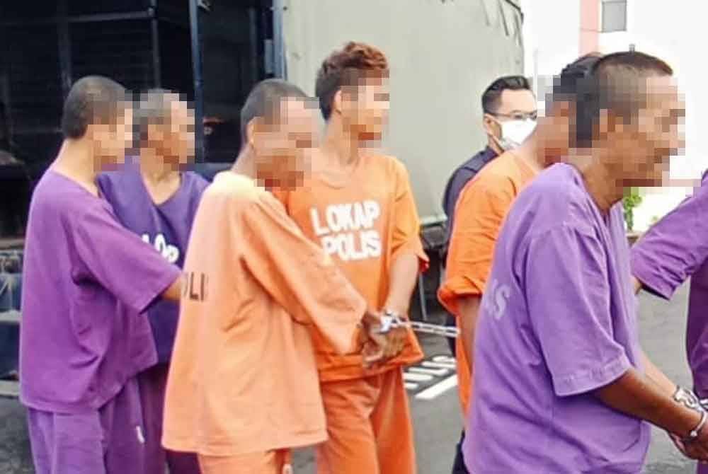 Tertuduh (empat dari kiri) tiba di perkarangan mahkamah.