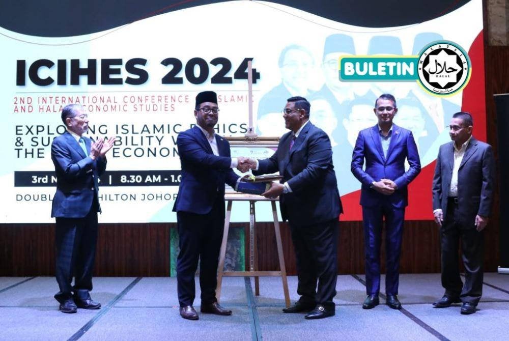DR ZULKIFLI (dua dari kiri) selepas merasmikan Persidangan Antarabangsa Ekonomi Islam dan Halal (ICIHES) kali kedua di Johor Bahru baru-baru ini. 