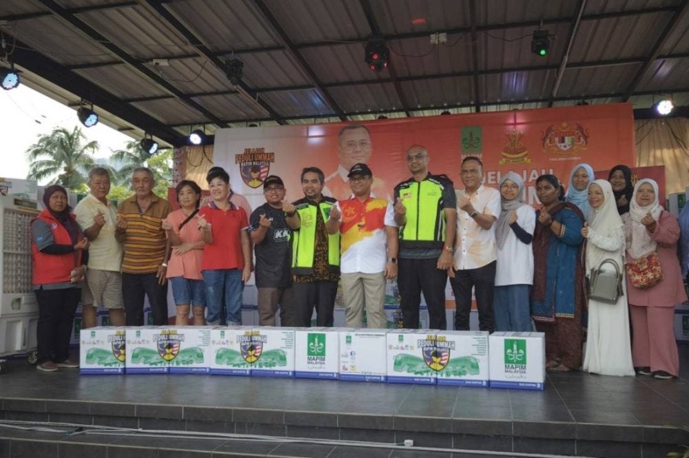 Amirudin (tengah) bergambar bersama penerima bakul makanan pada Jelajah Peduli Ummah pada Sabtu.