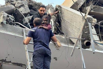 Penduduk Palestin membawa turun seorang kanak-kanak yang cedera dari sebuah rumah yang diserang dalam serangan Israel ke atas kem pelarian Jabalia di utara Semenanjung Gaza. Foto AFP