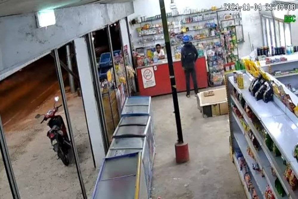 Tangkap layar video yang memaparkan kejadian samun di sebuah kedai runcit dengan menggunakan parang di Tasek Gelugor, Isnin lepas.