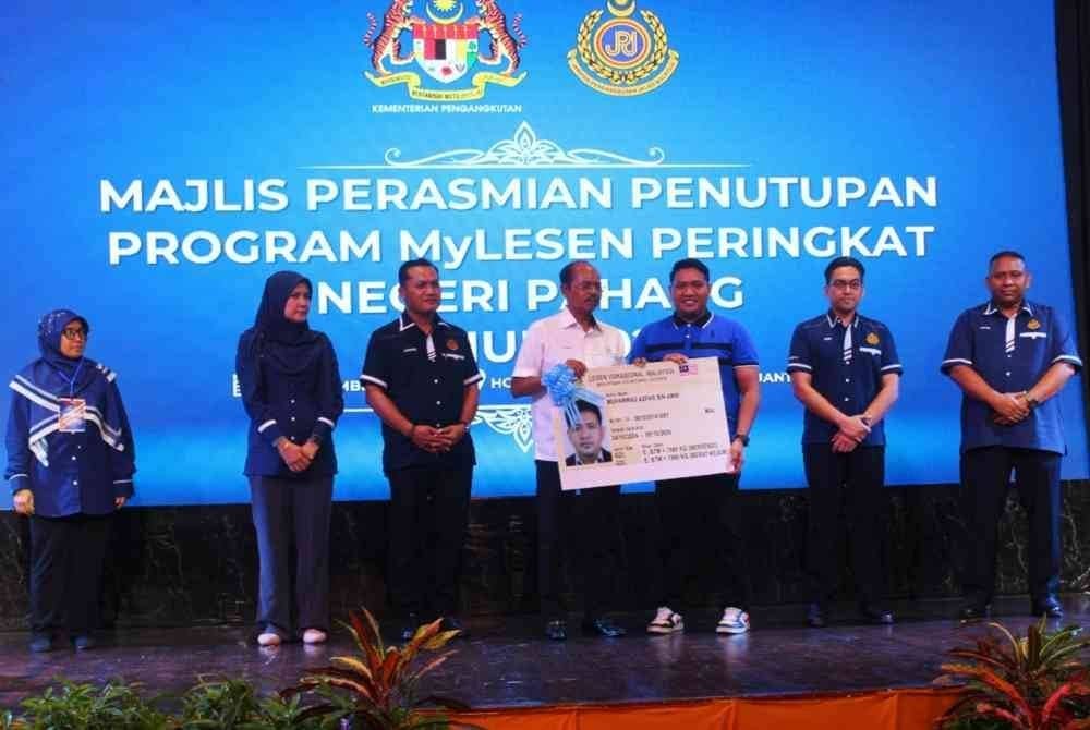Razali (empat dari kanan) menyerahkan lesen kepada salah seorang penerima sempena Majlis Perasmian Penutupan Program MyLesen Peringkat Negeri Pahang 2024 pada Ahad.