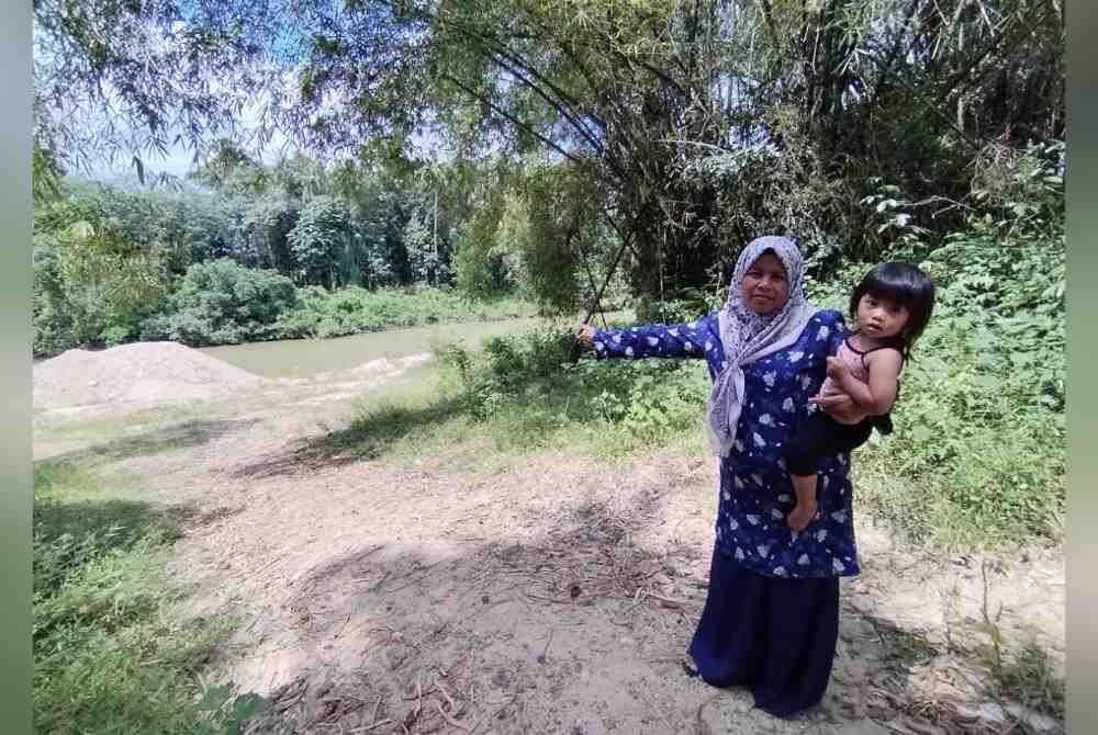 Nik Azizah menunjukkan jarak antara rumahnya dengan Sungai Jertih yang sejauh kira-kira 20 meter menyebabkan rumahnya antara terawal dinaiki air.