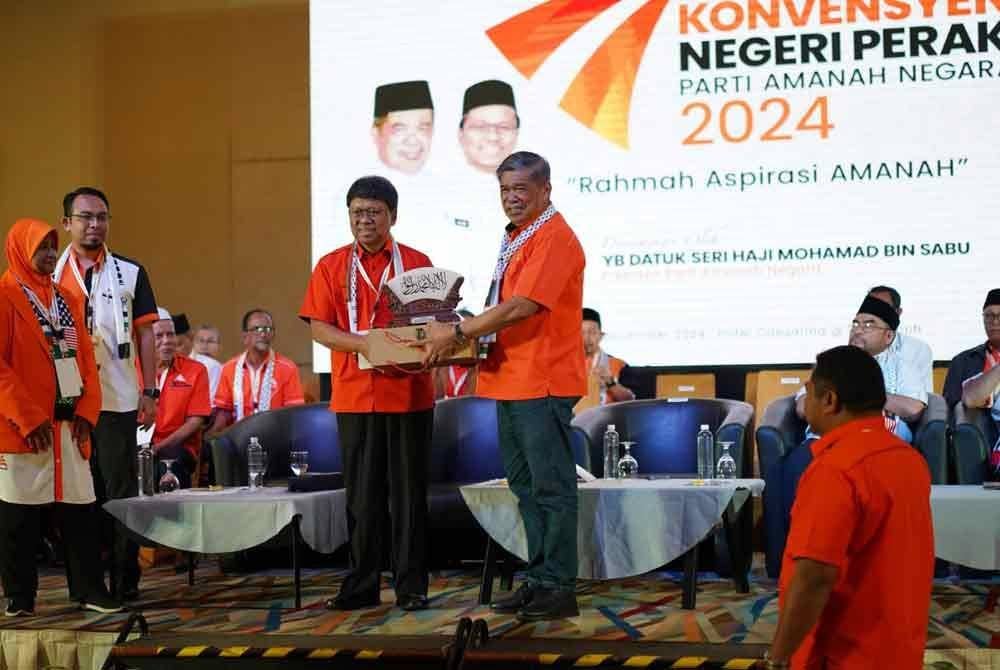 Mohamad (kanan) menerima cenderahati daripada Asmuni selepas menyempurnakan Konvensyen Amanah Negeri Perak 2024 di Pusat Konvensyen Casuarina pada Ahad.