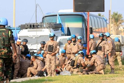 Pasukan pengaman UNIFIL membantu anggota yang cedera dalam serangan Israel berhampiran kenderaan mereka di pintu masuk ke bandar selatan Sidon, Lubnan. Foto AFP