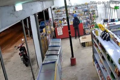 Tangkap layar video yang memaparkan kejadian samun di sebuah kedai runcit dengan menggunakan parang di Tasek Gelugor, Isnin lepas.