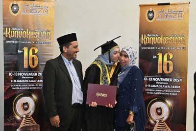 Norimrana (tengah) bersama ibu bapanya selepas menerima Anugerah Pelajaran Diraja pada sidang pertama Majlis Idul Ilmi (Istiadat Konvokesyen) Ke-16 Universiti Sultan Zainal Abidin (UniSZA) pada Ahad.