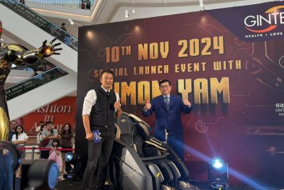 Cheh Yak (kanan) bersama Simon (kiri) ketika majlis pelancaran Kerusi Urut Wellness edisi terhad Iron Man pada Ahad.