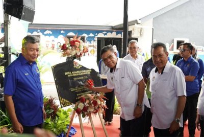 Saifuddin (dua dari kanan) menandatangani plak perasmian Baitul Mahabbah Darul Aman di Jalan Kuala Kedah pada Ahad.