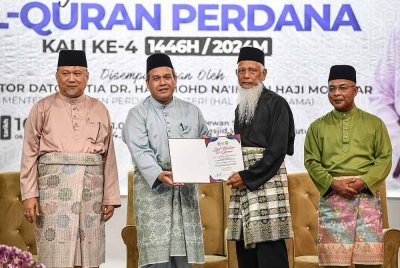 Muhamad Razak (dua, kiri) menyampaikan sijil khatam al-Quran kepada peserta, Mat Hashim Abdul Rahman pada Majlis Khatam Al-Quran Perdana Kali ke-4 di Masjid Wilayah Persekutuan pada Ahad. Foto Bernama